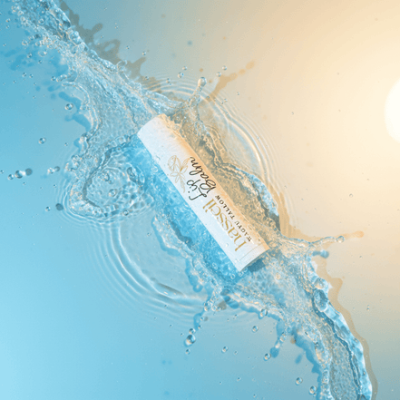 Lip balm on a beach with water and sand